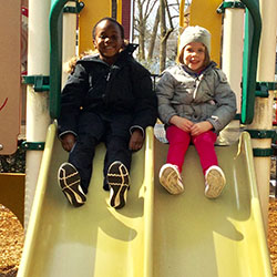 two children playing on slide